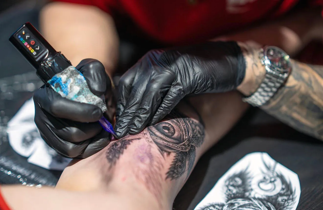 Award-winning tattoo artist working on detailed tattoo